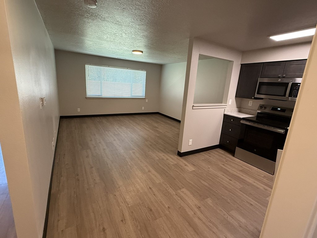 A kitchen area with a microwave, oven, and cabinets.
