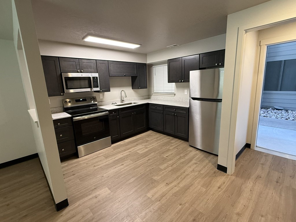 A kitchen with black cabinets and stainless steel appliances.