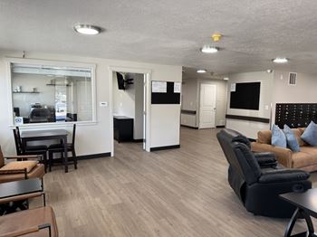 A living room with a couch, chairs, and a dining table.