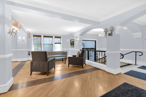 A living room with a grey couch and a black chair.