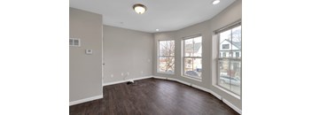 A room with a window and a wooden floor.