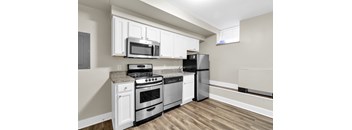 A kitchen with a black refrigerator, stove, and oven.