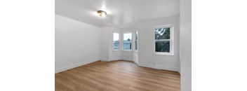 Empty room with wooden floor and white walls.