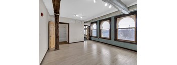 A room with wooden floors and a large window.