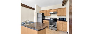 A kitchen with wooden cabinets and a black stove top oven.