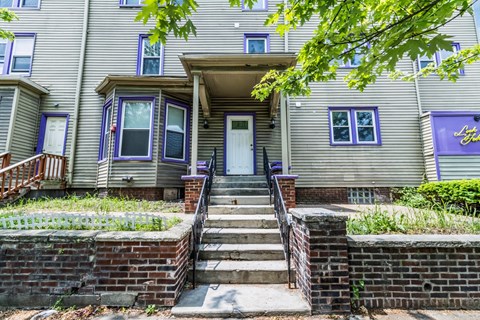 A house with a front porch and stairs leading up to it.