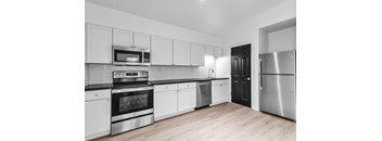 A modern kitchen with stainless steel appliances and white cabinets.