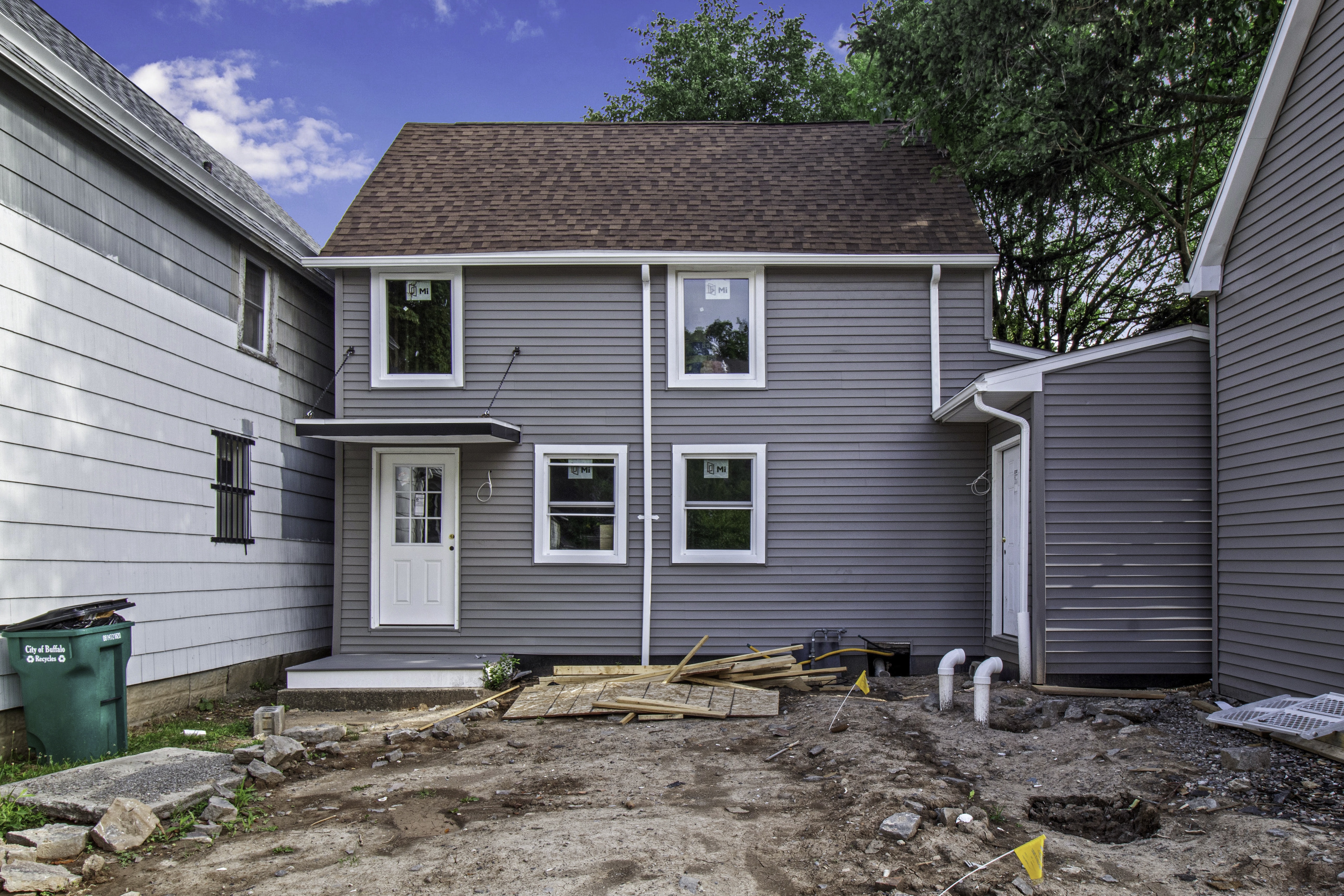 A grey house with a white door and windows.