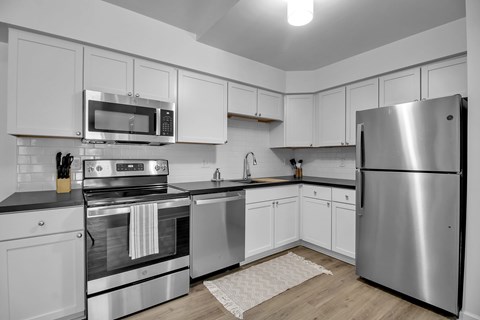A modern kitchen with stainless steel appliances and white cabinets.