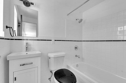 A white bathroom with a toilet, sink, and bathtub.
