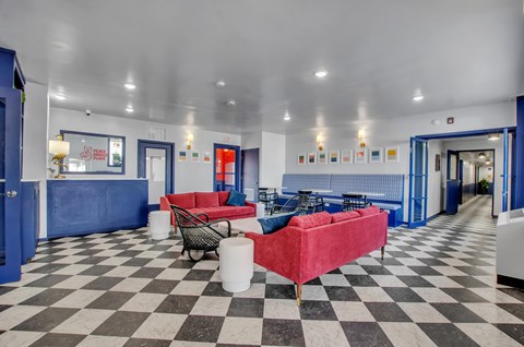 A black and white checkered floor in a room with blue walls and furniture.