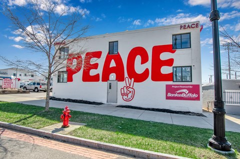 A white building with the word "PEACE" written on it in red.