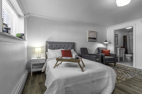 A bedroom with a large bed and a wooden tray on it.