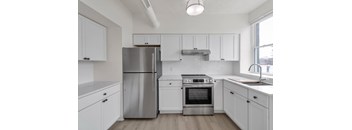 A modern kitchen with white cabinets and stainless steel appliances.