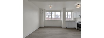 A kitchen with white cabinets and a grey floor.