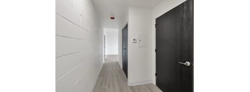 A long hallway with a black door on the right.