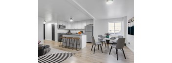 A modern kitchen with a dining table set for two.