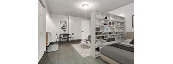 A bedroom with a bed, a desk, and a bookshelf.