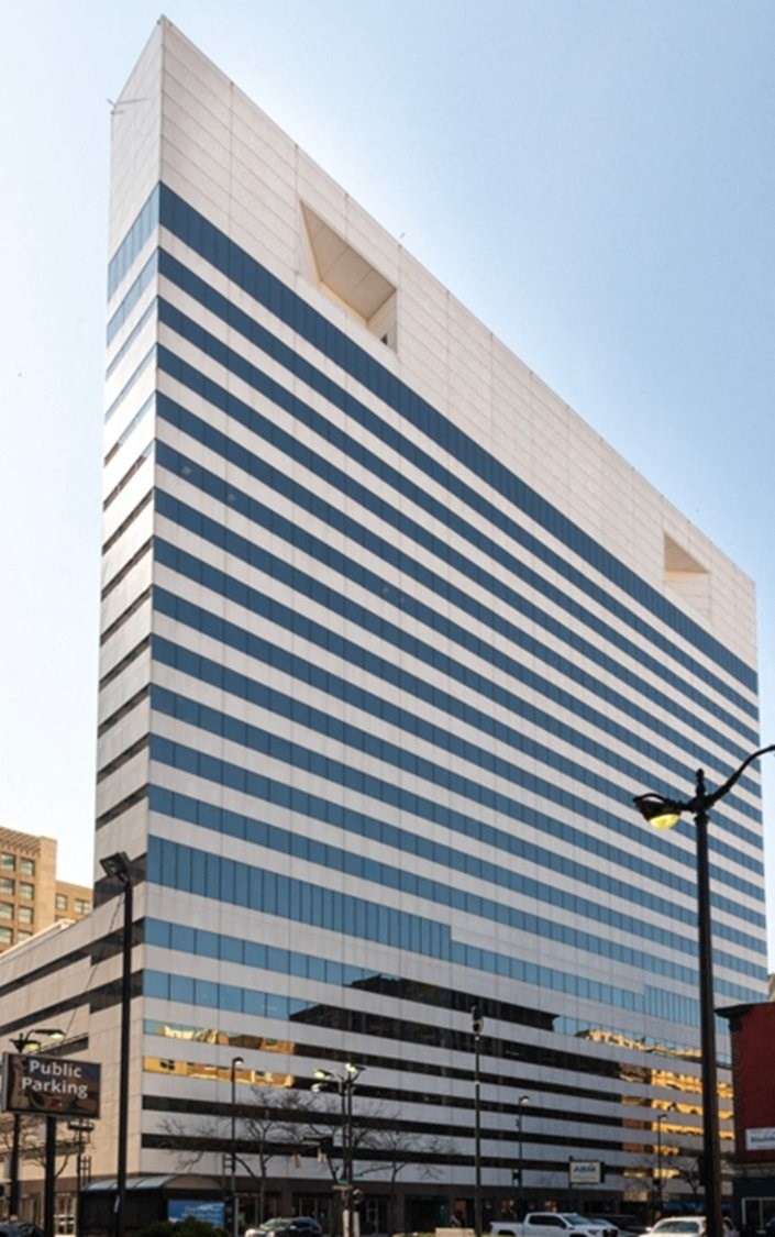 A tall building with a blue and white striped facade.