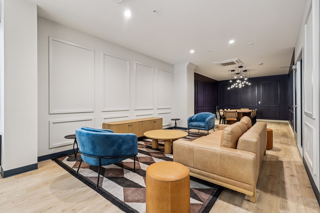 A living room with a blue chair and a tan couch.