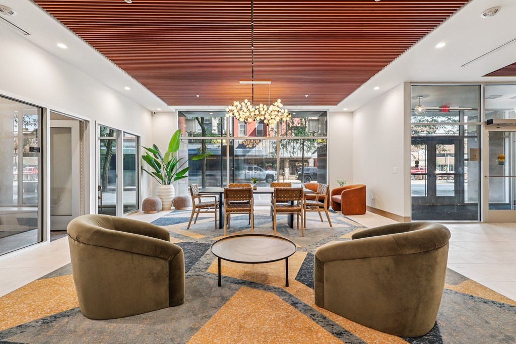A modern waiting room with brown chairs and a round table.