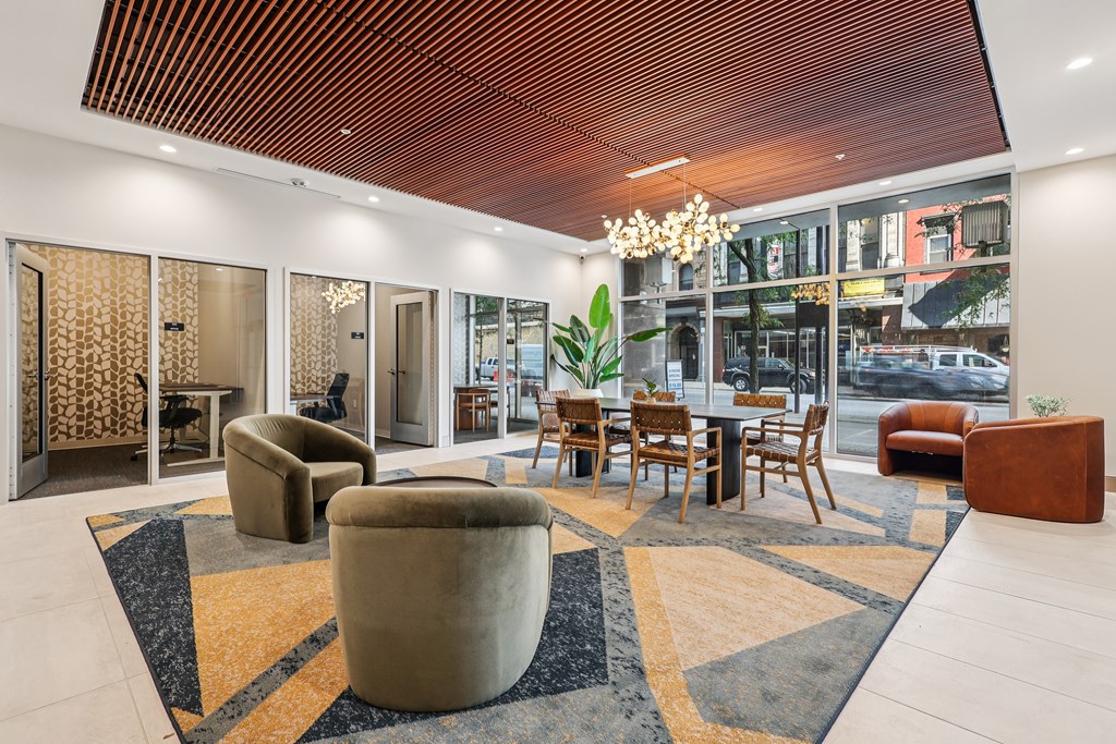 A modern living room with a wooden ceiling and a large rug.
