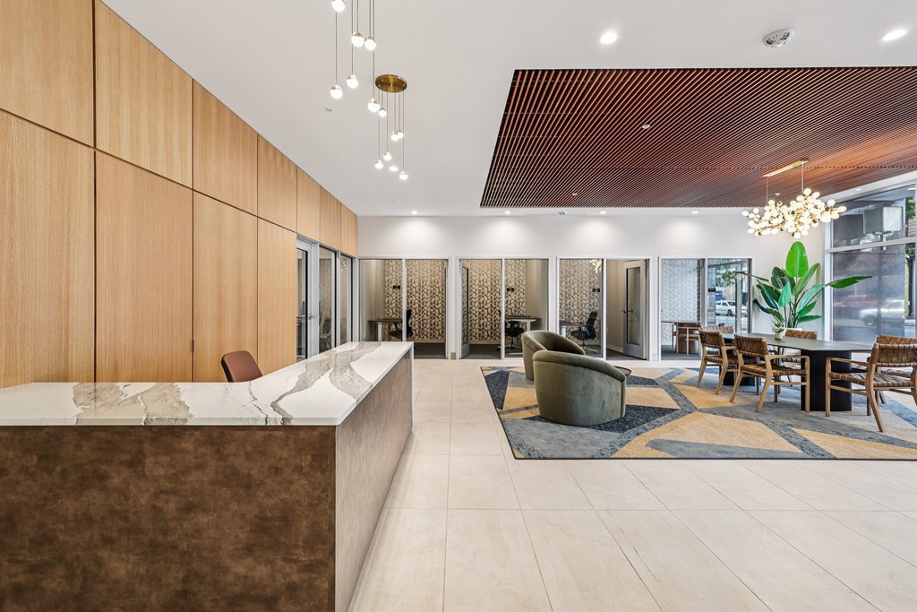 A modern office lobby with a reception desk and seating area.