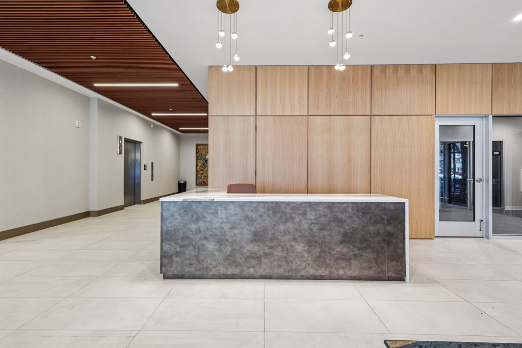 A reception area with a concrete counter and wooden panels on the wall.