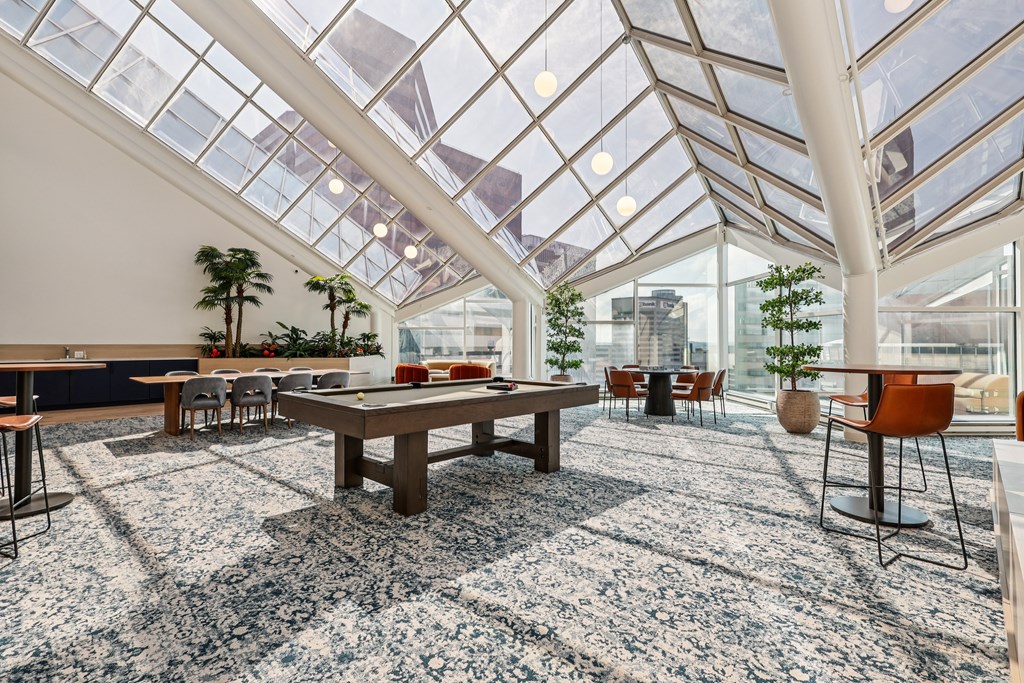 A room with a glass ceiling and a table surrounded by chairs.
