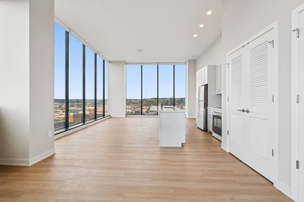 A spacious kitchen and living room with a view of the city.