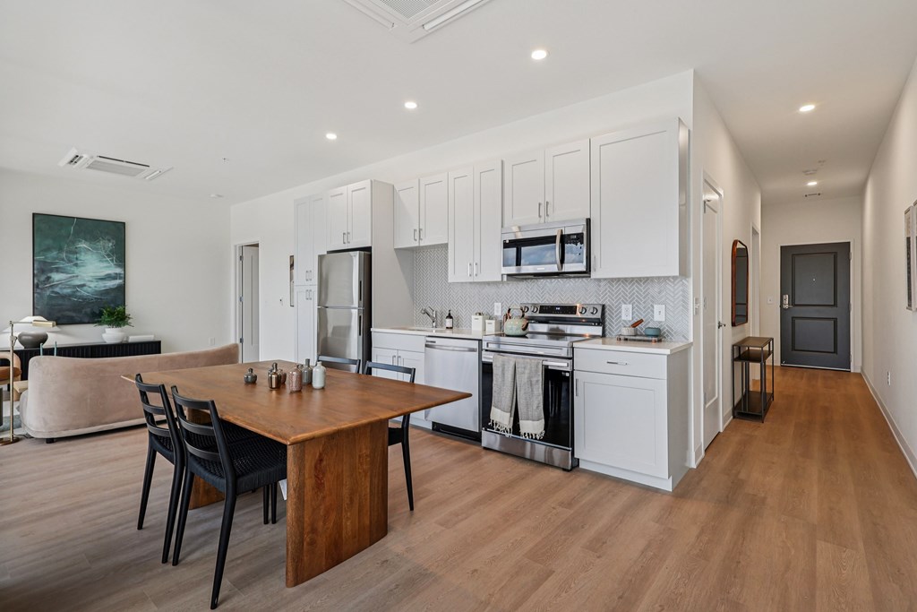 A modern kitchen with a wooden table and chairs.