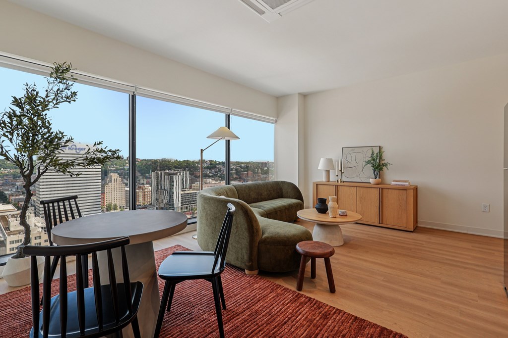 A living room with a view of the cityscape outside the window.