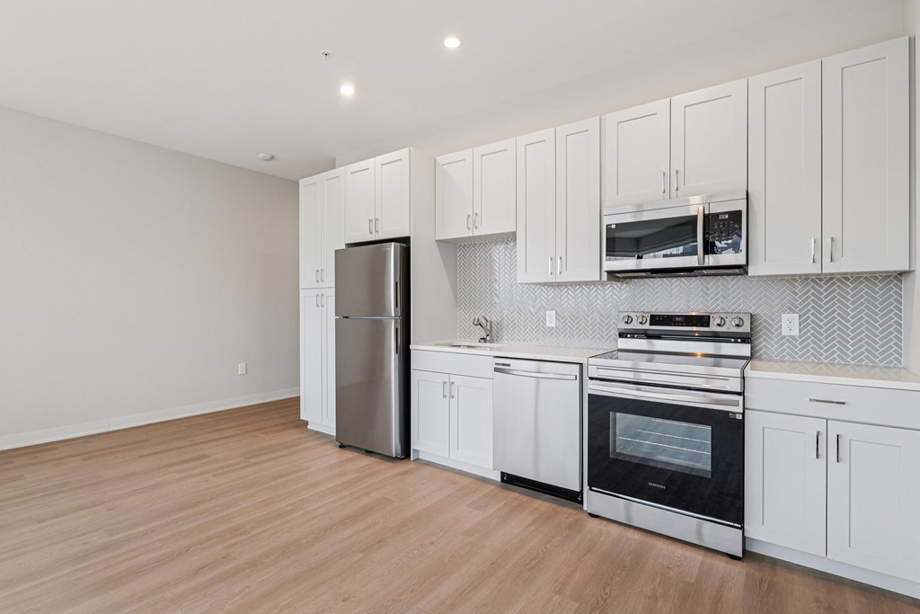 A kitchen with white cabinets and stainless steel appliances.