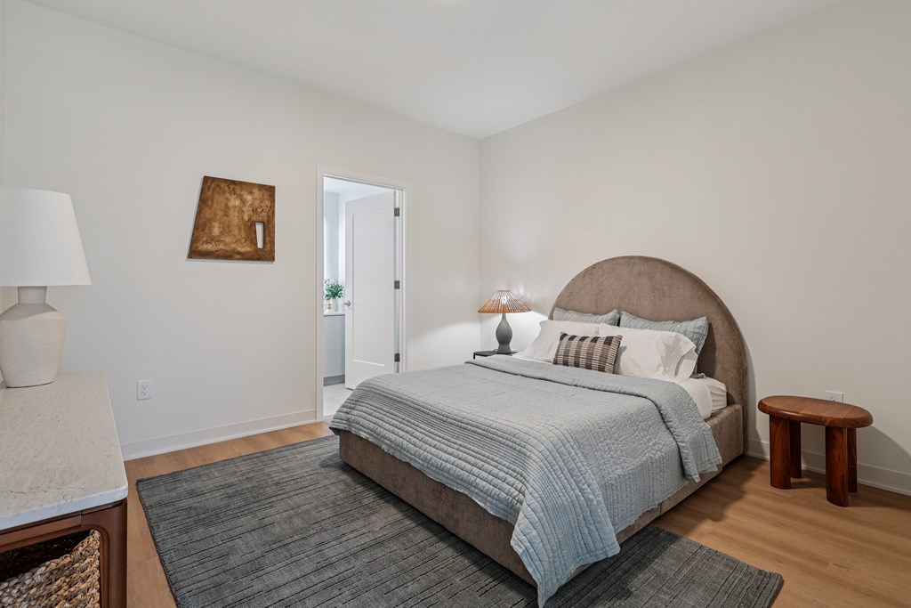 A bedroom with a large bed and a small table.