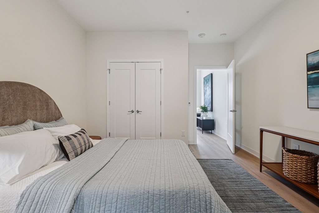 A bedroom with a large bed and a painting on the wall.