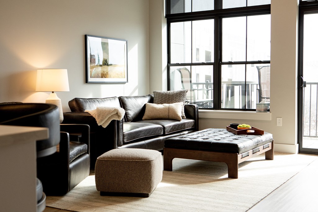 A black leather couch with a white throw blanket on it at The Pearl, Fort Wayne, IN 46802