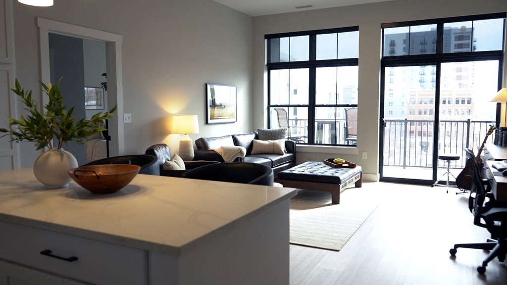 A modern living room with a large window and a view of the city. at The Pearl, Fort Wayne, IN, 46802