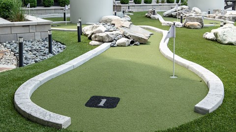 A golf hole number 1 surrounded by rocks and sand bunkers.
