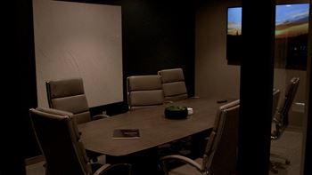 A conference room with a table, chairs, and a screen displaying the time. at The Pearl, Fort Wayne, IN, 46802