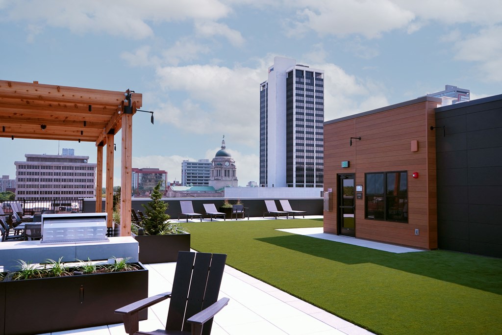 A wooden pergola is on a patio with a bench and a planter at The Pearl, Indiana