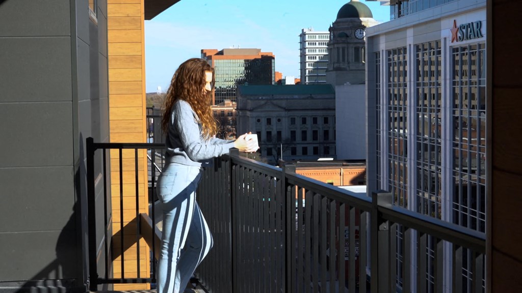 Girl on the balcony drinking coffee at The Pearl, Indiana