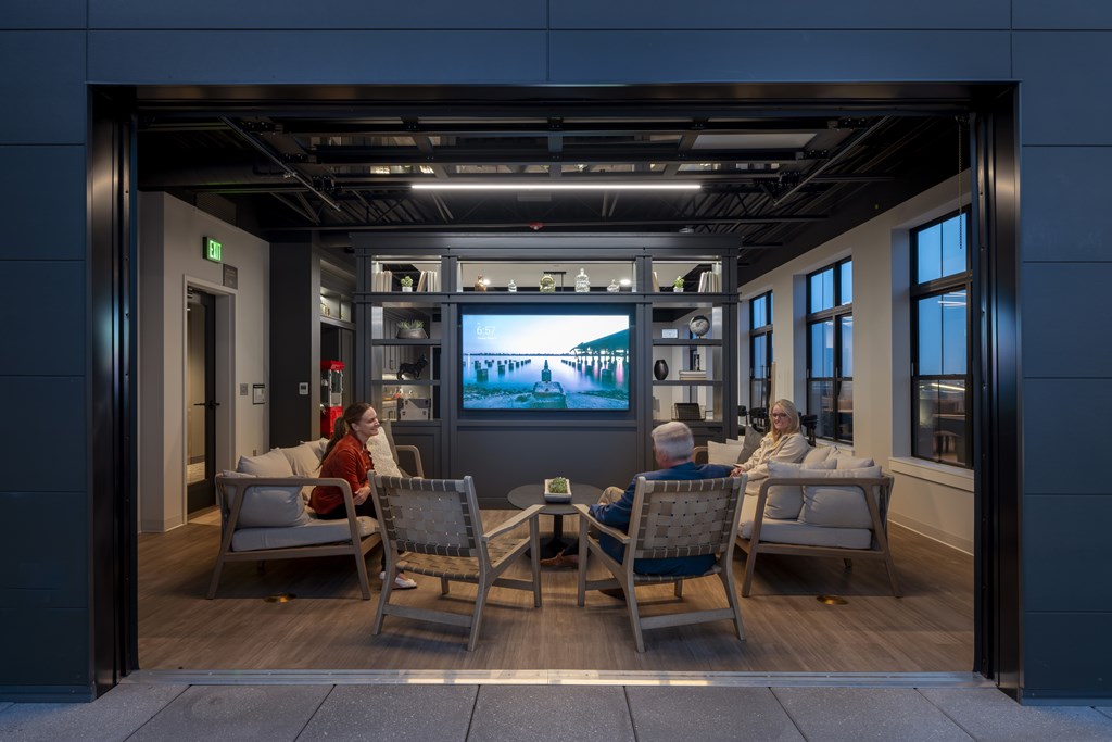 A man and a woman are sitting in chairs in a room with a television in the background. at The Pearl, Fort Wayne, IN