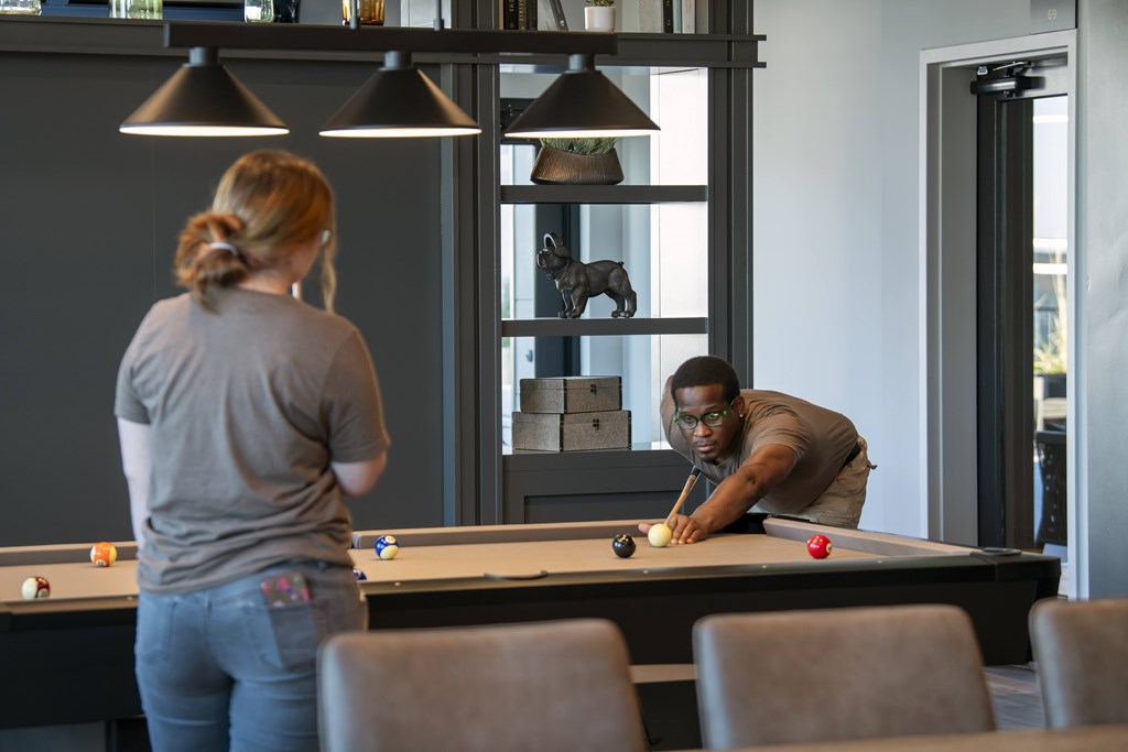 A man and a woman playing pool in a room. at The Pearl, Fort Wayne, IN