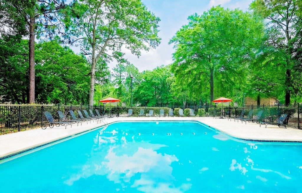 a swimming pool with chairs and umbrellas around it