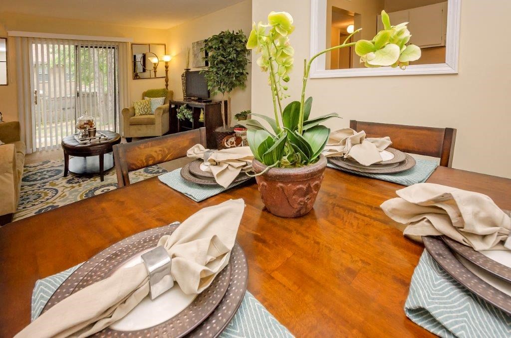 a dining room table with plates and a potted plant