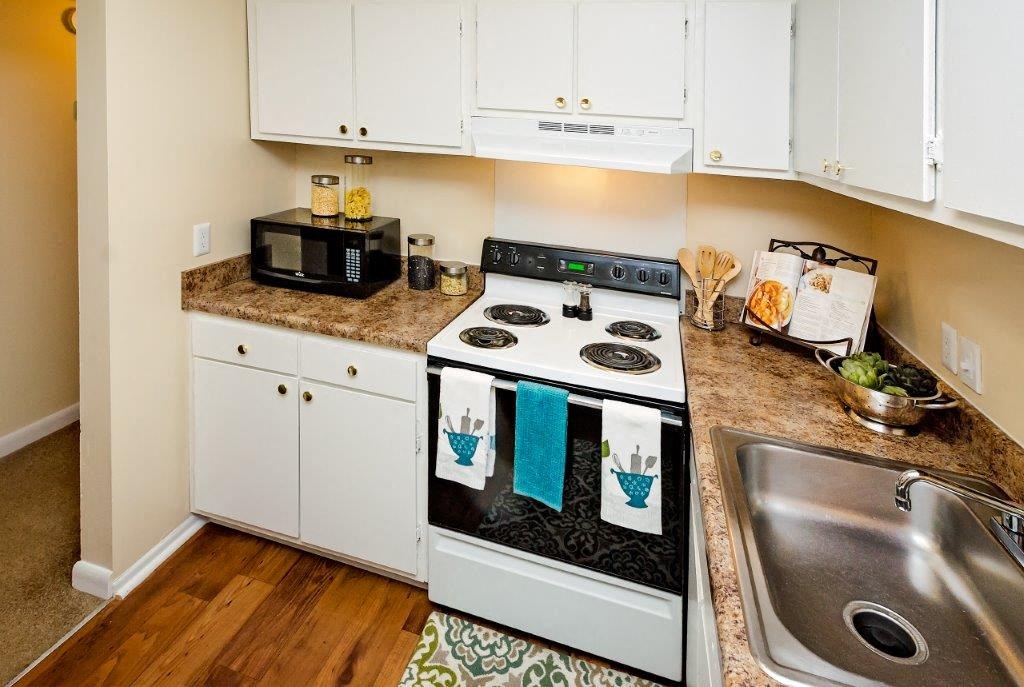 a kitchen with white cabinets and a stove and a sink