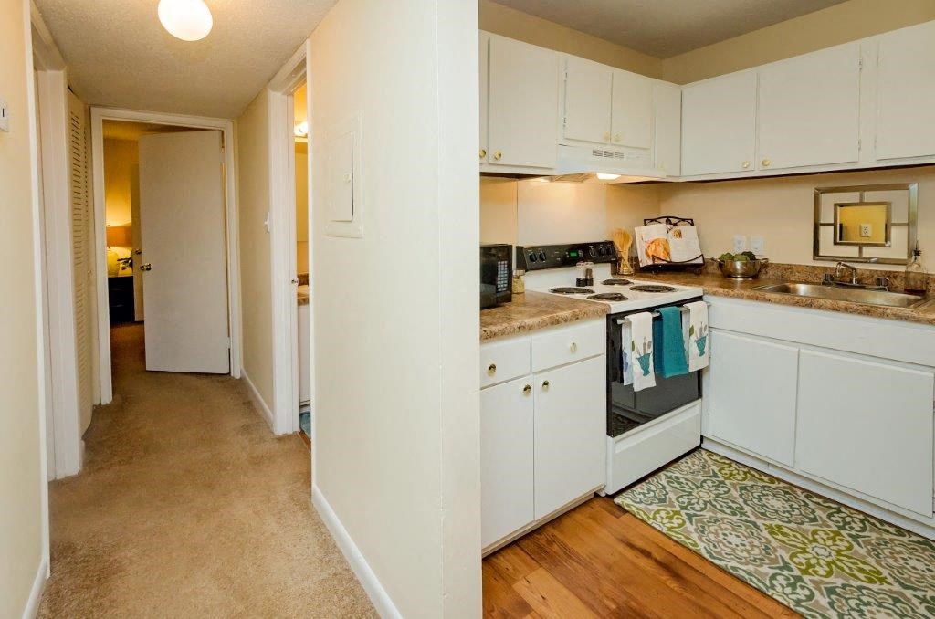 a kitchen with white cabinets and a stove and a sink