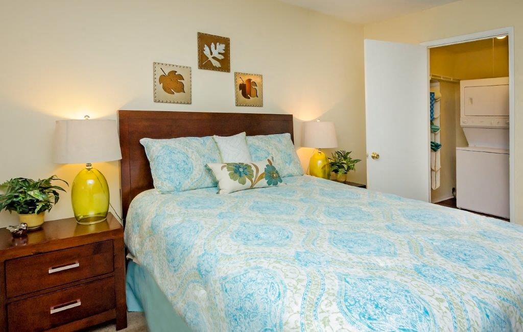 a bedroom with a bed and two lamps and a closet