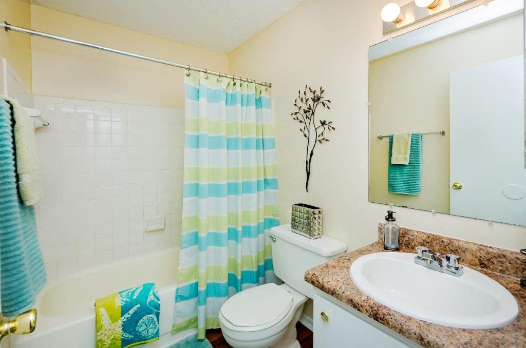 a bathroom with a shower curtain and a toilet and a sink