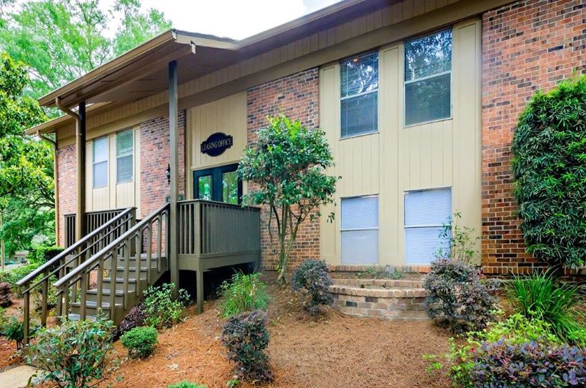 the front of a brick house with a porch and stairs